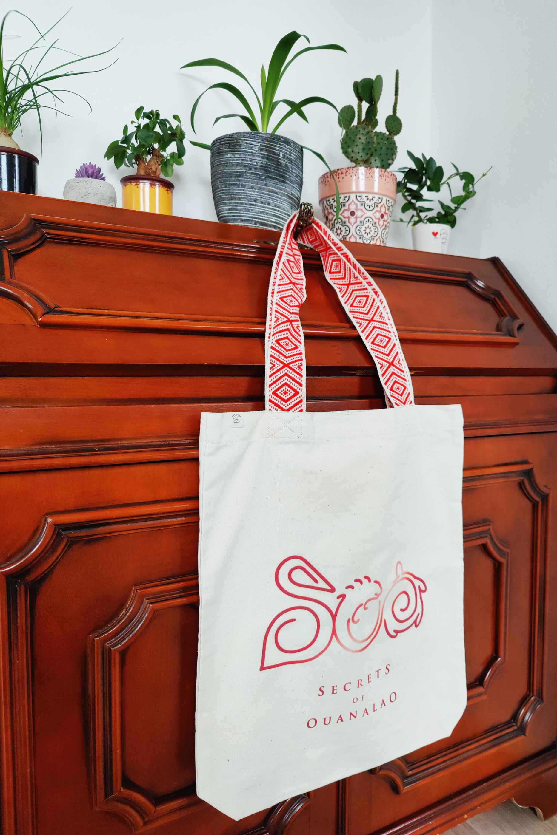 Vegan tote bag with red handles and logo, including inside zipper pocket. The tote bag is made of recycled cotton.