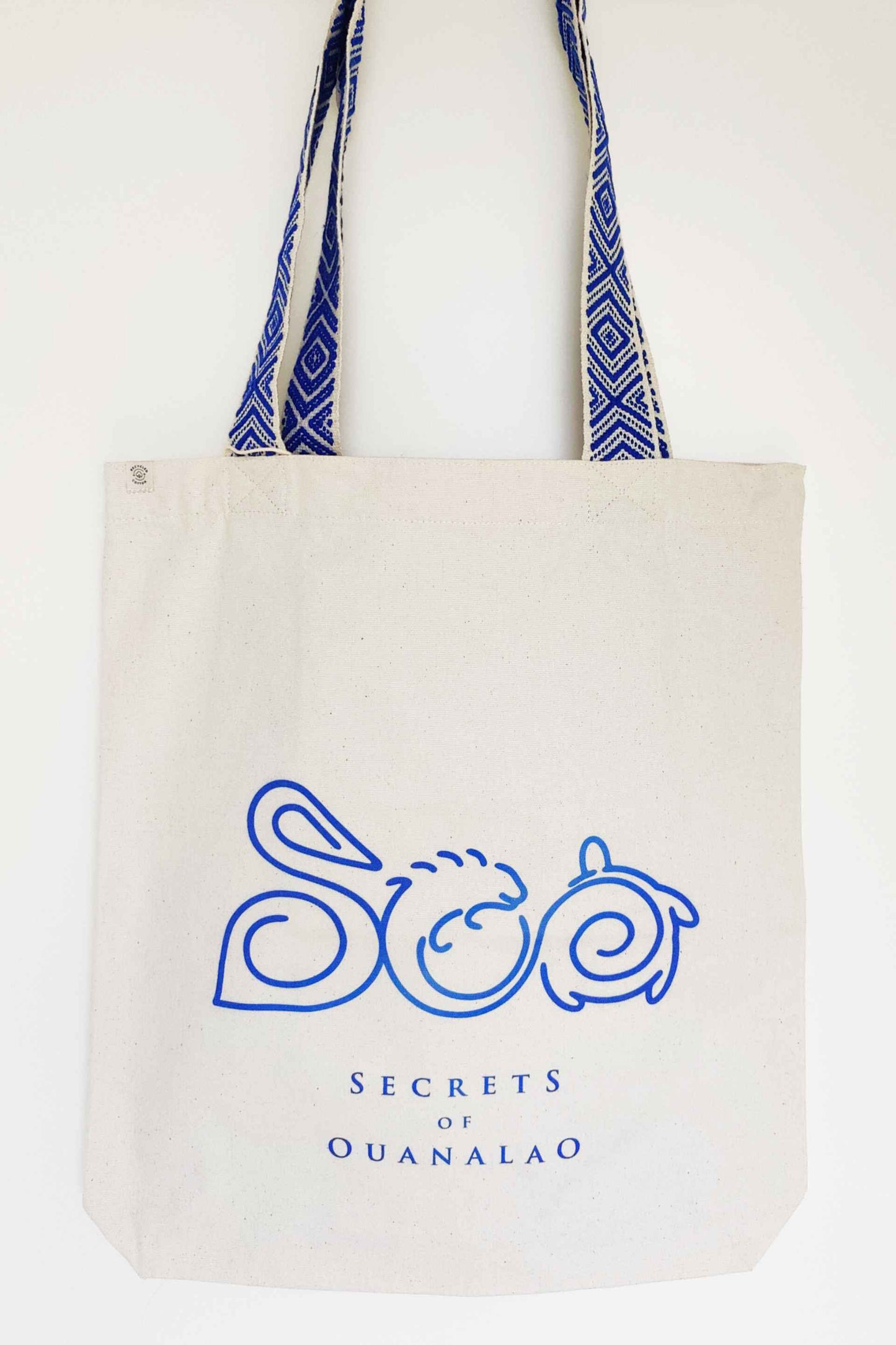 Vegan tote bag with blue handles and logo, including inside zipper pocket. The tote bag is made of recycled cotton.