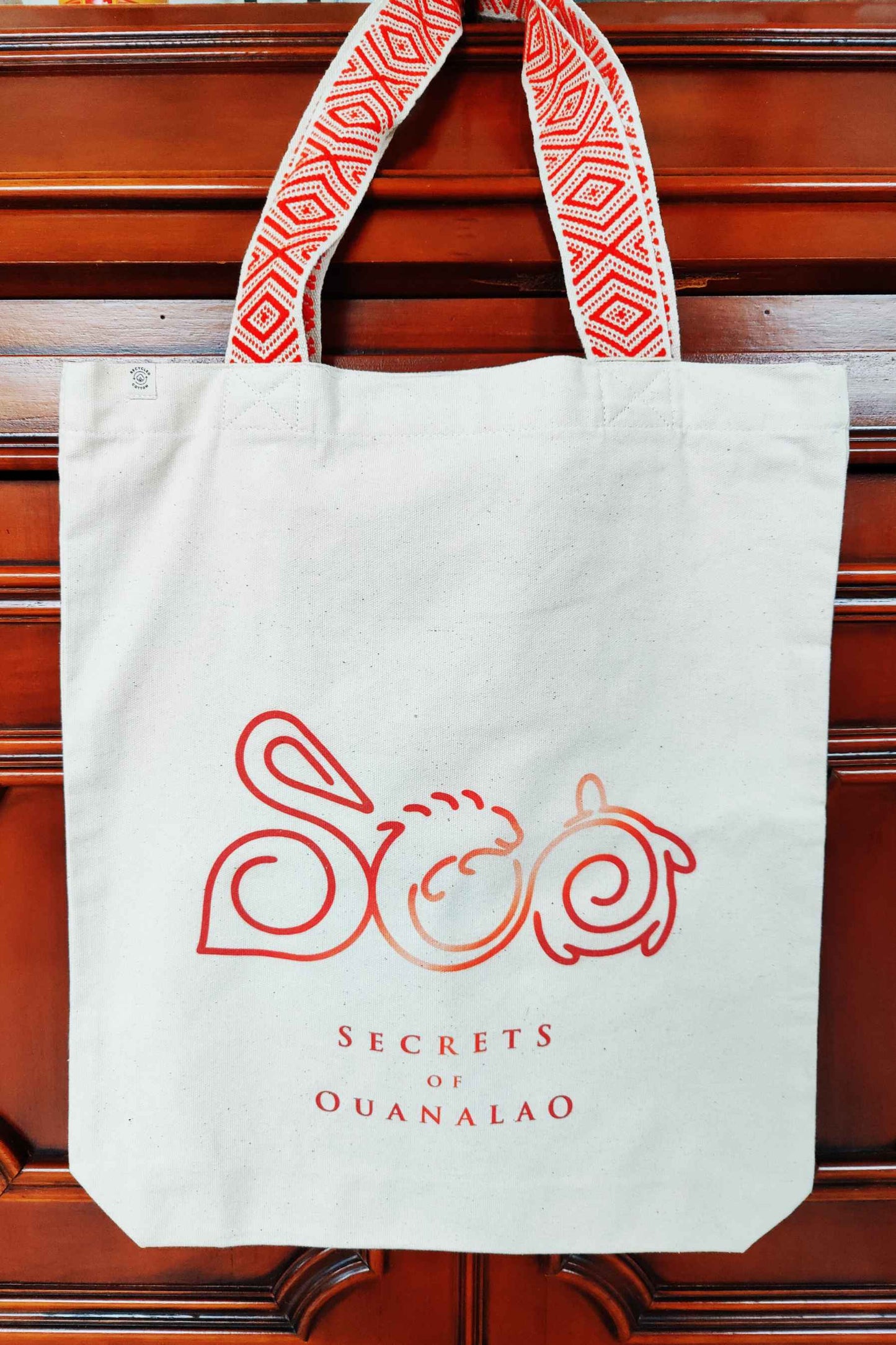 Vegan tote bag with red handles and logo, including inside zipper pocket. The tote bag is made of recycled cotton.