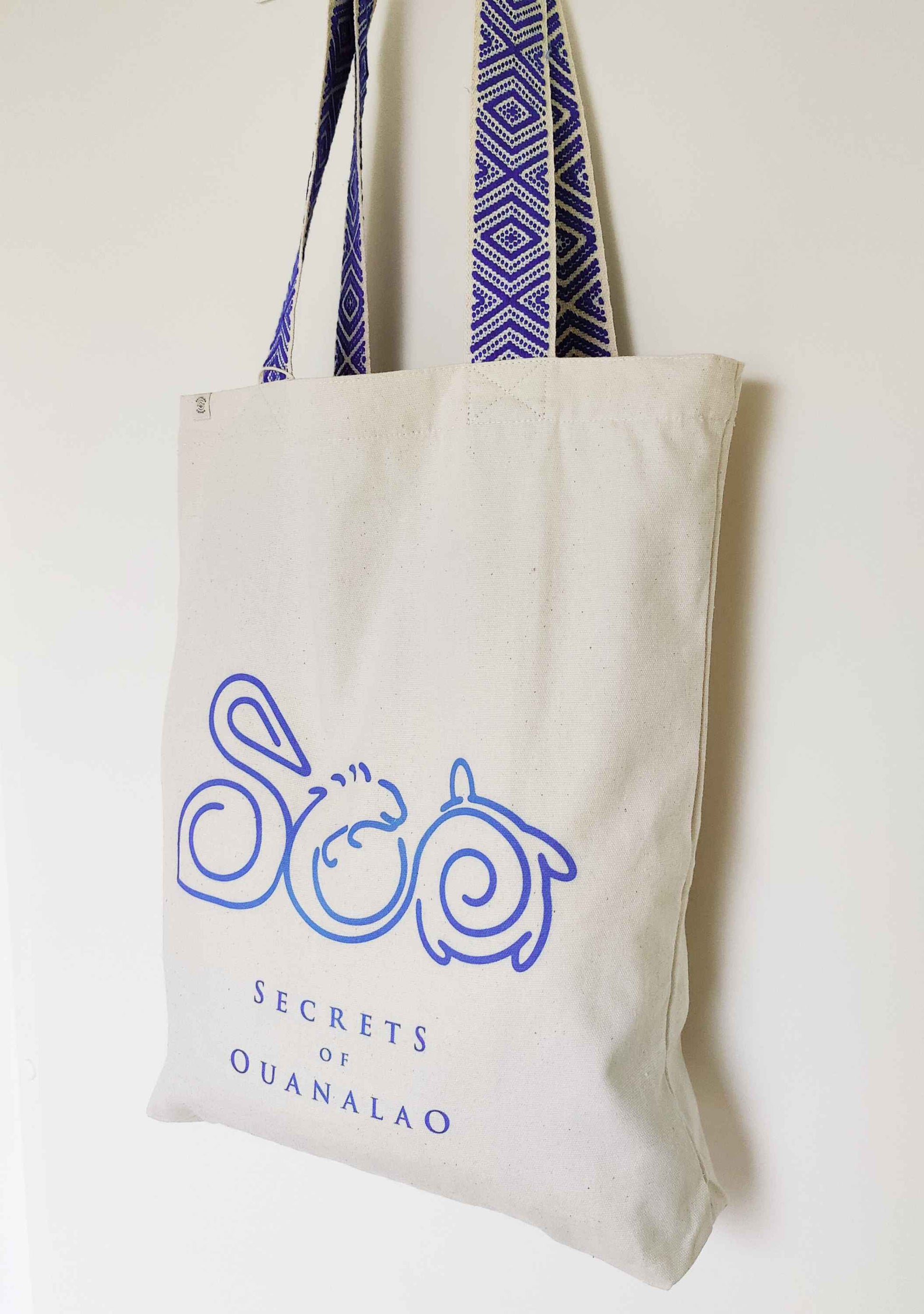 Vegan tote bag with blue handles and logo, including inside zipper pocket. The tote bag is made of recycled cotton.